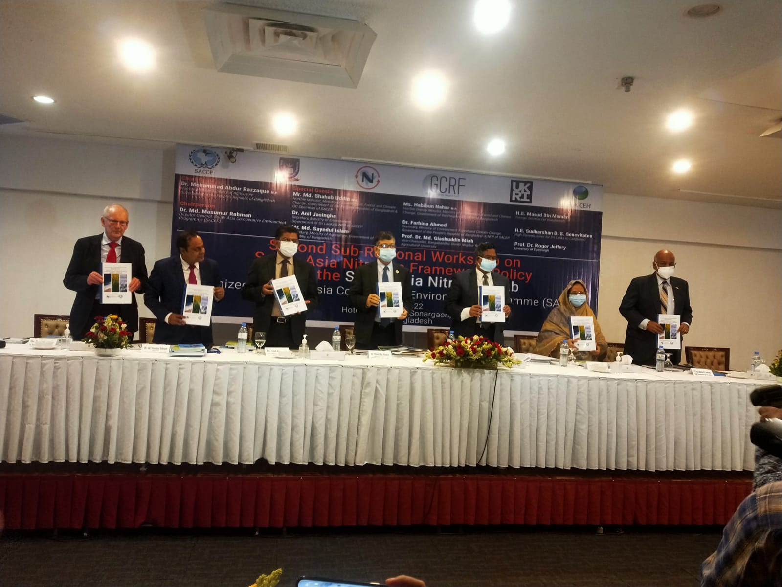 Delegates stood behind table holding report